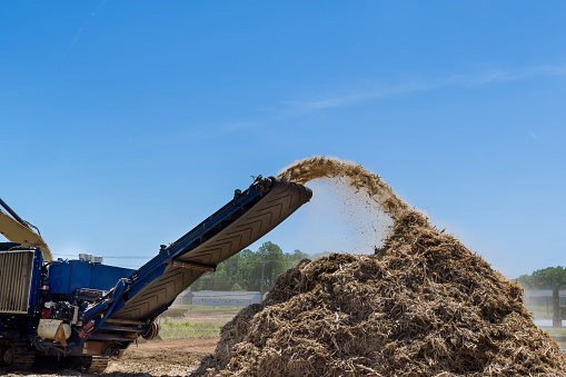 In order to prepare the land for building housing development, a large industrial shredder machine will work to shred roots into chips in order to prepare the soil