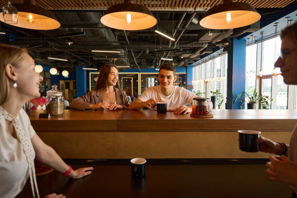 istock Man and three women have fun for informal communication in cafe 1428549453
