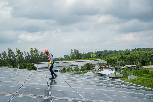 Engineer man or worker checking the operation of the system solar panels or solar cells on roof,Renewable energy source,Eco technology for electric power.