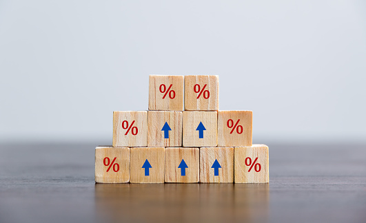 Closeup wood cubes with percentage symbol, Percent and upwards increasing arrows on wooden cubes. Financial interest mortgage rates increase or price commission raise, growth business, finance tax.