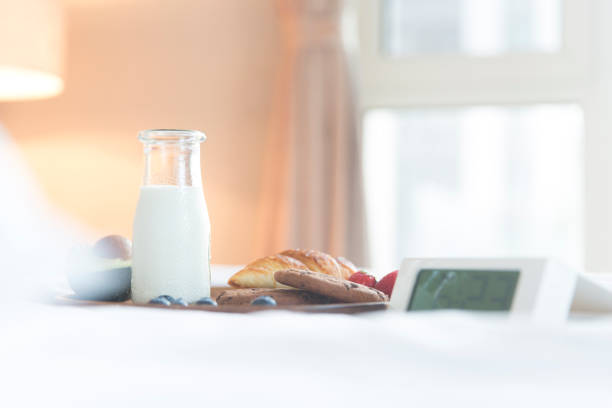 Rustic breakfast table scene featuring sliced bread, glass jars filled with grains and preserves, and a jug of milk, arranged in a cozy, nostalgic setting. Soft, warm lighting and retro film effects create a vintage, homely atmosphere ideal for themes of comfort, tradition, rural life, and slow living.