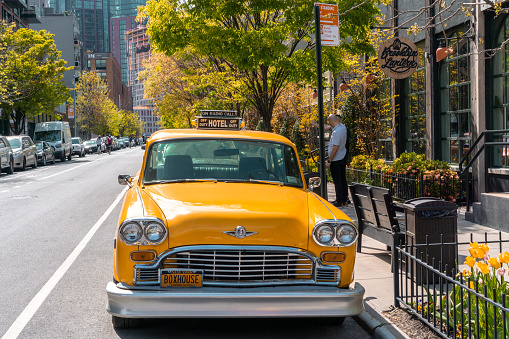 Brooklyn, NY - May 1 2022: Yellow retro taxi waiting in front of Box House Hotel in Greenpoint, Brooklyn, NY