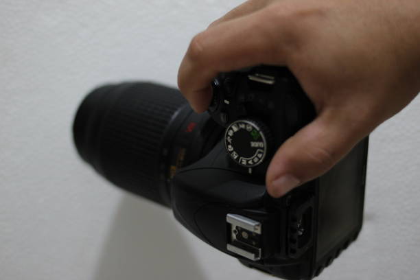 istock Photographer holding a professional black digital photo camera. 1428562648