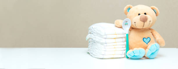 istock Stack of diapers with toy teddy bear with spoon on table. set for baby shower with copy space 1428568896