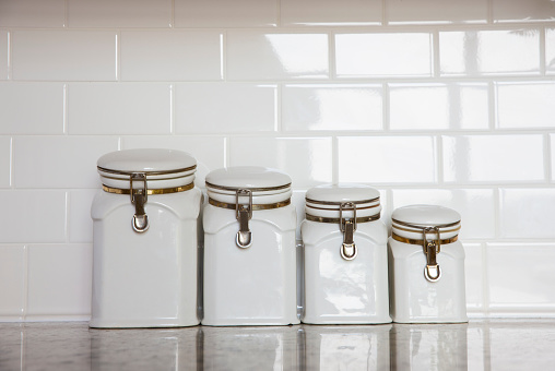 An extreme close up vertical photograph of an isolated in white empty clear glass canning jar.