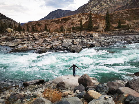 woman standing in front of mountain river