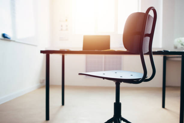 Empty work space chair, desk with laptop stock photo
