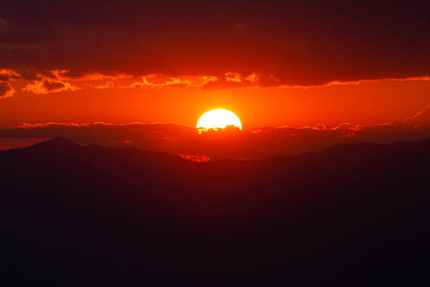 lumière rouge du coucher du soleil derrière un ciel nuageux. - dramatic sky dusk night sustainable resources photos et images de collection