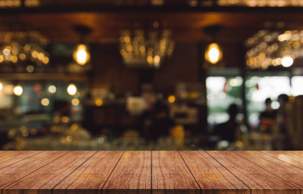 istock Empty wooden table top with lights bokeh on blur restaurant background. 1428576237