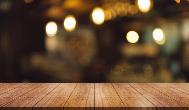 istock Empty wooden table top with lights bokeh on blur restaurant background. 1428576408