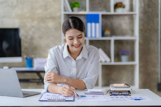 istock Asian woman working using laptop computer in modern office make an account analysis report real estate investment information tax and financial system concepts 1428581461