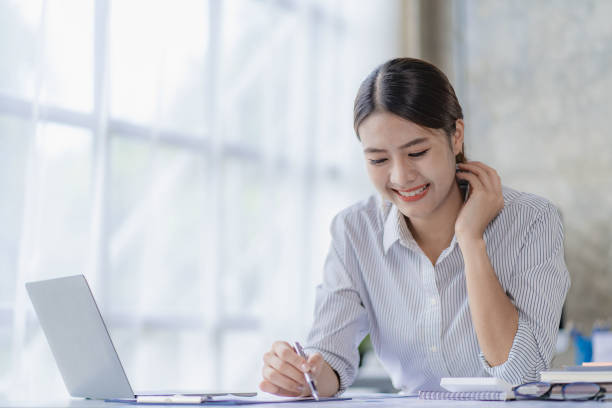 istock Asian woman working using laptop computer in modern office make an account analysis report real estate investment information tax and financial system concepts 1428581475