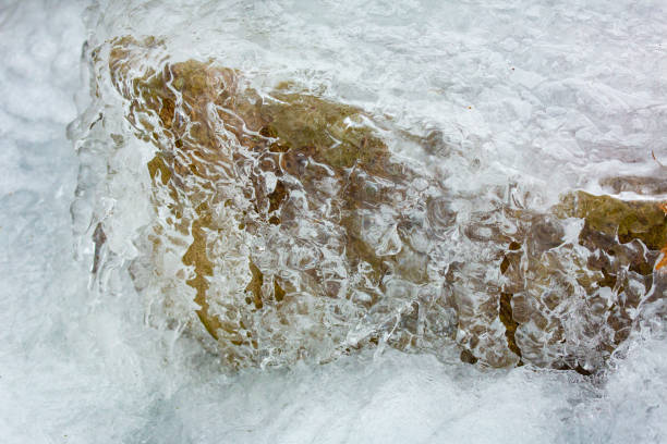 Ice formation on a rock in a frozen brook in winter, with subtle colors at Goodwin State Forest in Chaplin, Connecticut.