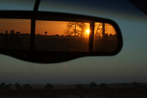 Sunset in a rearview car mirror