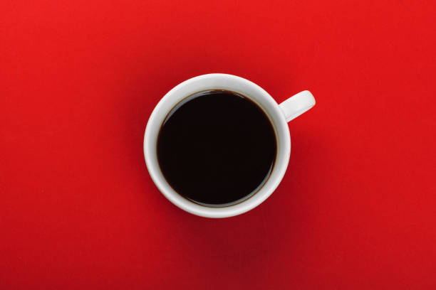 istock Coffee cup with coffee beans on red background. 1428593648