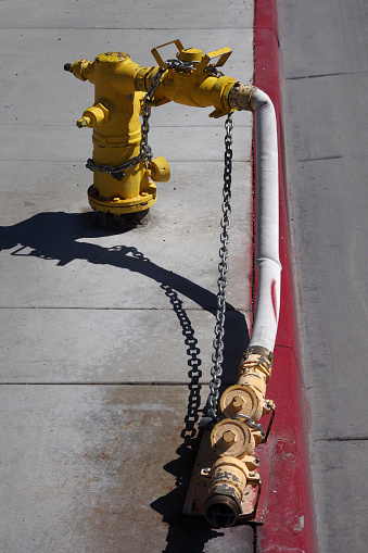 Fire hydrant with extension hose and valves on a red curb