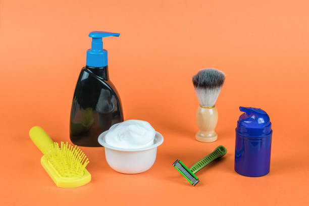 a comb and a set for shaving and washing on an orange background. minimal concept of men's hygiene. - shampoo merchandise packaging razor imagens e fotografias de stock