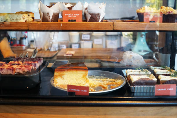 istock Wooden bakery and pastry display counter shelf contains custard and carrot cake, Raspberry cream cheese brownie, Chocolate muffin 1428603094