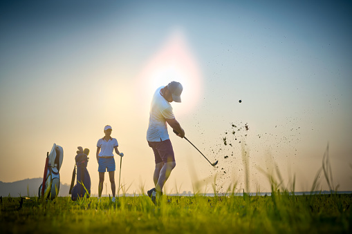 Couple lovers golf player or competitors playing golf together in the mode of terrible shot of golf ball hitting away from the main fairway, golf ball run out off the main fairway course, terrible shot of hit a golf ball returns to the main fairway
