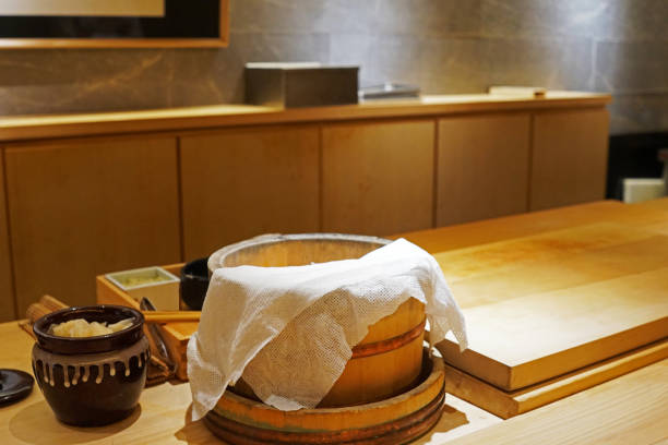 木製のライスボウル、発酵生姜瓶、新鮮なわさびで飾られた寿司と刺身準備ステーションのインテリアバーデザインとカウンター装飾
