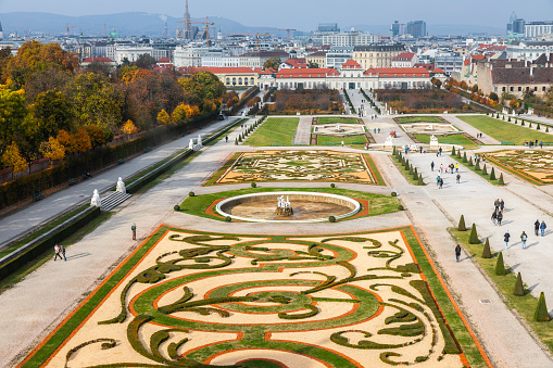 Vienna, Austria - October 30, 2019: Aerial view of decorating garden in Belvedere Palace. Tourists walking around the park during autumn season.
