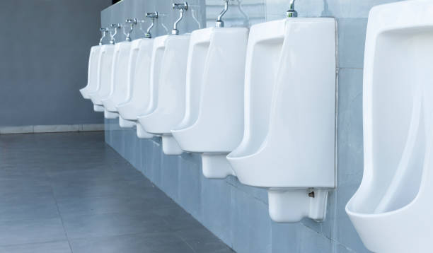 men's room with white porcelain urinals in line in gas station - urinal clean contemporary in a row imagens e fotografias de stock