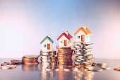Miniature colorful house on stack coins