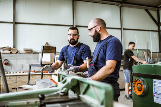 istock Young carpenter talking to his colleague while working in a workshop. 1428610677