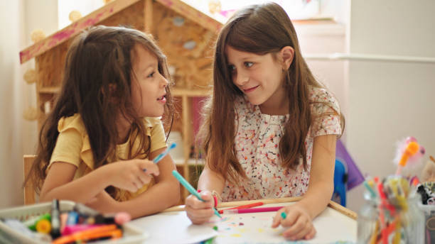 istock Sisters at home drawing and painting together 1428614805