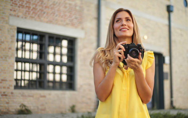 istock Beautiful woman taking pictures with her camera while exploring a city 1428616234