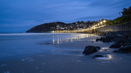Street lights lit up St Clair beach at dawn, Dunedin.