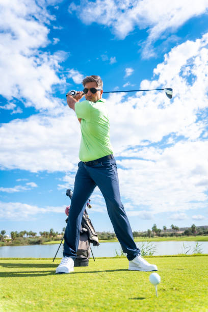 istock A player playing golf on a golf course, hitting the ball next to a lake 1428618056