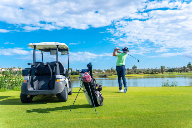 istock Playing professional golf on golf course, hitting the ball by a lake, buggy 1428618117