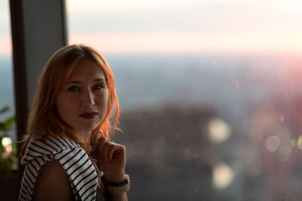 istock Young woman at the window 1428623450