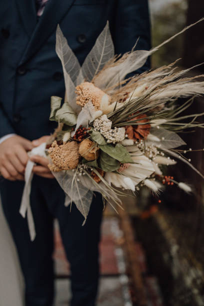 istock Vertical shot of wedding bouquet in mans 1428623805