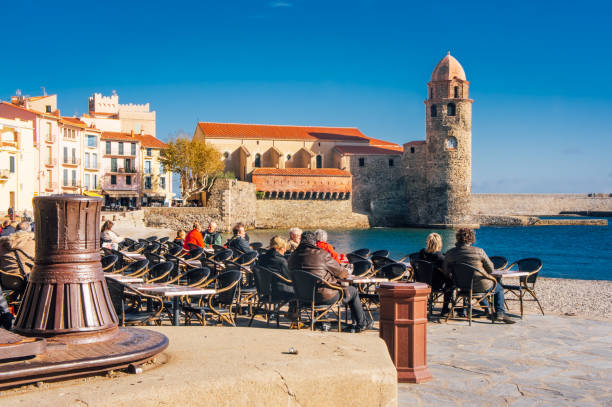 people drinking coffee outside in Collioure, France France, Collioure, 8 November 2017: people drinking coffee outside in Collioure, France collioure stock pictures, royalty-free photos & images