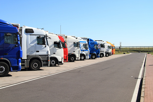various trucks are parked in a parking lot on the highway