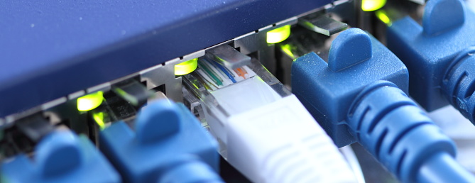 blue RJ45 plugs in a router at work
