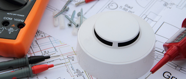 Smoke detectors are installed, he lies on the wiring diagram with a screwdriver and a meter