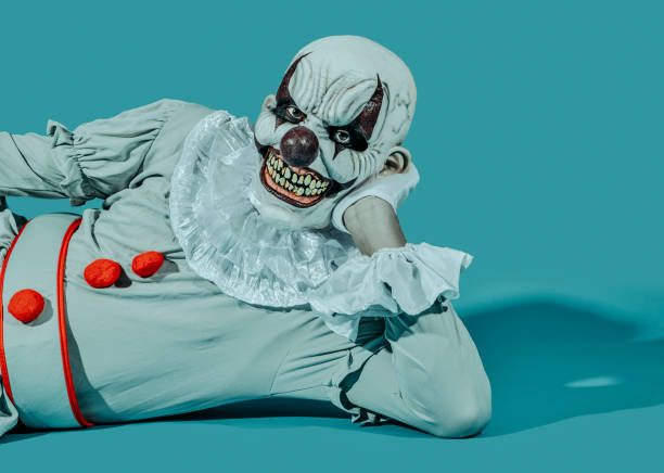 istock a creepy evil clown is lying on his side 1428630394