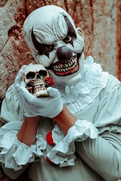istock creepy evil clown holds a skull in his hands 1428630497