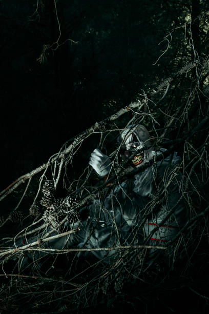 istock creepy evil clown hiding in the woods at night 1428631004
