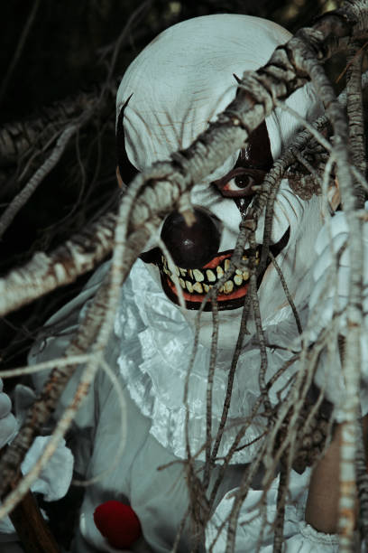 istock creepy evil clown hidding in the woods 1428631087