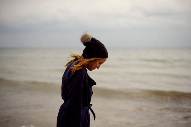 Autumn mood in nature with model. Gray and cloudy day at the sea