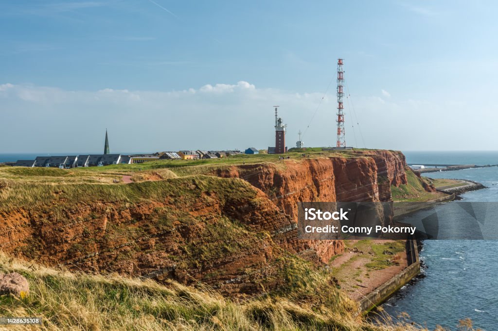 Red sandstone cliffs, Helgoland, Schleswig-Holstein, Germany View to the cliff coast and Oberland with lighthouse and radio tower on the island of Helgoland, North Sea, Pinneberg district, Schleswig-Holstein, Germany Atlantic Ocean Stock Photo
