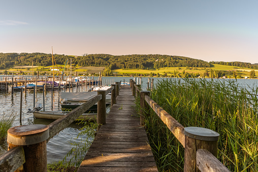 Wooden jetty and boats in the harbor of Oehningen on the Hoeri peninsula, in the background the Swiss shore near Eschenz in the Canton of Thurgau.