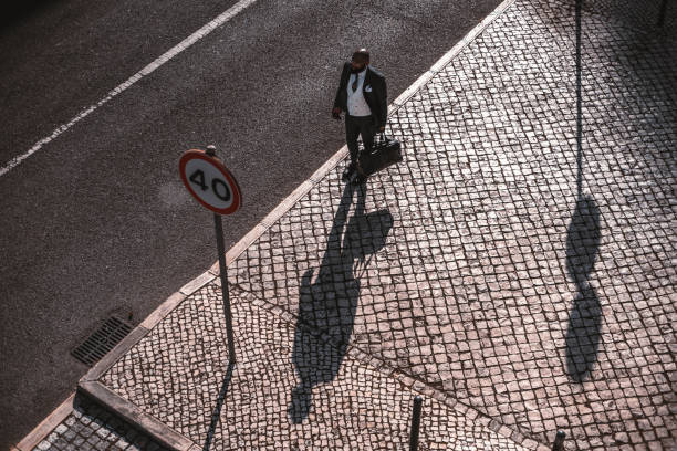 un gars noir en costume au bord de la route - copy space road sign sky above photos et images de collection