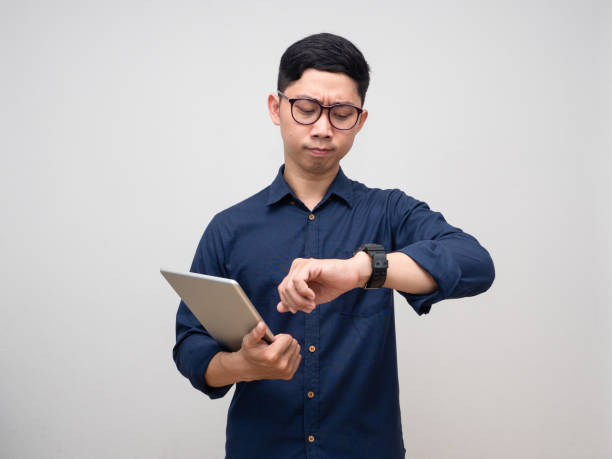 istock Businessman hold tablet looking at his watch hurry emotion isolated 1428636633