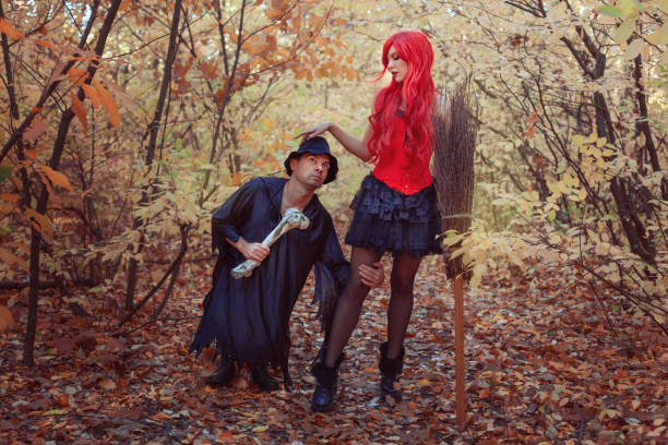 istock Beautiful witch and dwarf in the autumn forest. 1428638611