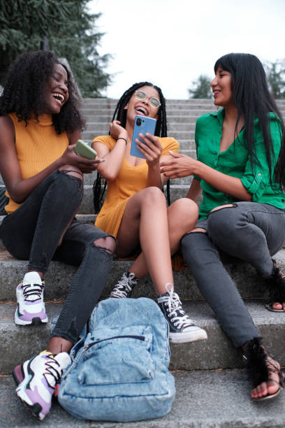 istock Three young students sitting on the stairs outdoors chatting and having fun 1428638713